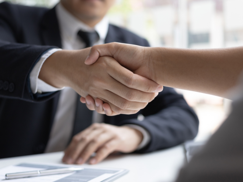 a close-up of a recruitment business owner shaking hands with his new hire